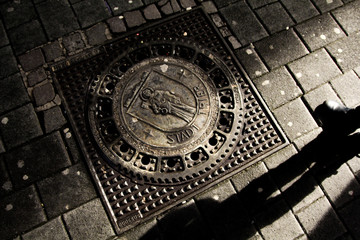 Plaque d'égout ancienne à Trèves avec ombre