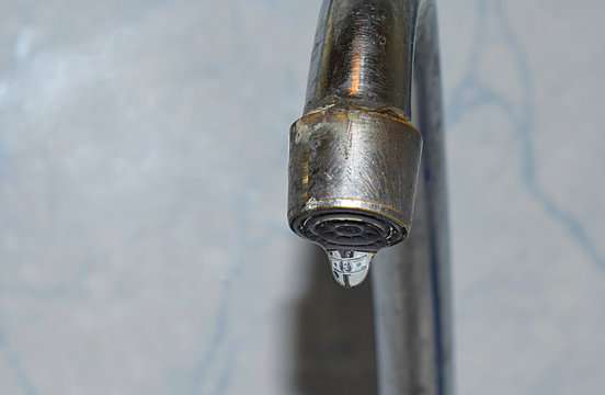 A drop of water falling from a faulty tap.