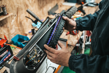 Man repairing electrical scooter in special workshop. © hedgehog94