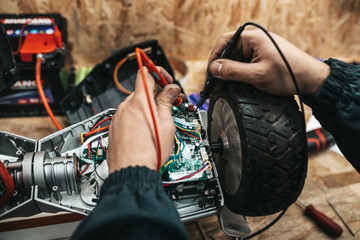 Man repairing electrical scooter in special workshop. © hedgehog94