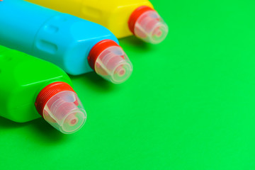 Bottles of detergents on color background