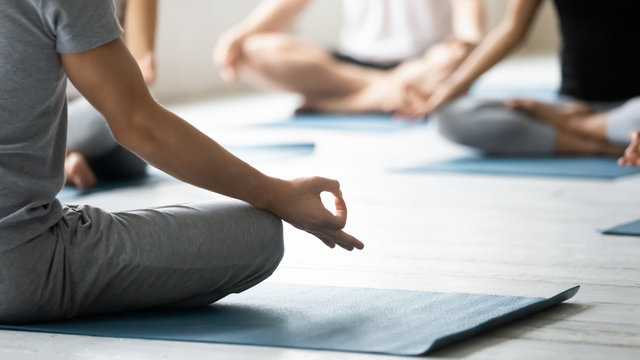 Yoga coach and session participants meditating close up concept image
