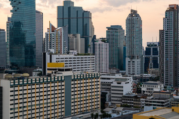 Fototapeta na wymiar Aerial cityscape of picturesque Bangkok at sunset from rooftop. Panoramic sunrise skyline of the biggest city in Thailand. The concept of metropolis.