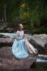 The Tale of the Mermaid. Tale of the River Nymph. Girl in a blue dress by the river.