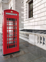 Obraz premium red telephone box beyond white building. London, Great Brittain 