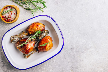 Grilled chicken drumstick bbq with rosemary on a stone gray background.