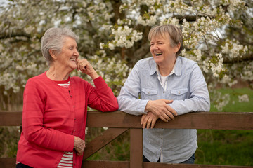Portrait of elderly mother and daughter outdoors in garden 