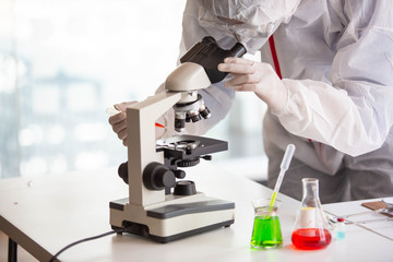 Microbiologists or doctors are testing a sample of biological tubes contaminated by Corona-virus Covid 19 in a laboratory with a biological tube for analysis and and film samples of infected lung