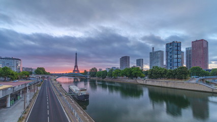 Fototapeta na wymiar Eiffel Tower sunrise timelapse with boats on Seine river and in Paris, France.
