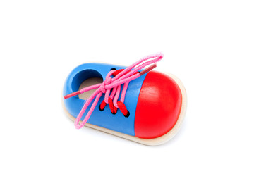 A shoe of plywood - development toy for kids to learn how to lace shoelaces isolated on white background