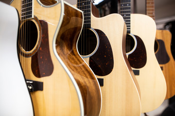 Close up of classic guitar drapped in a row in a huge musical shop, instrument shop, instrument concept