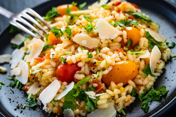 Risotto with parmesan on black stone background