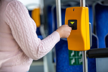 Young woman validates ticket in a public transport during transportation, transportation concept