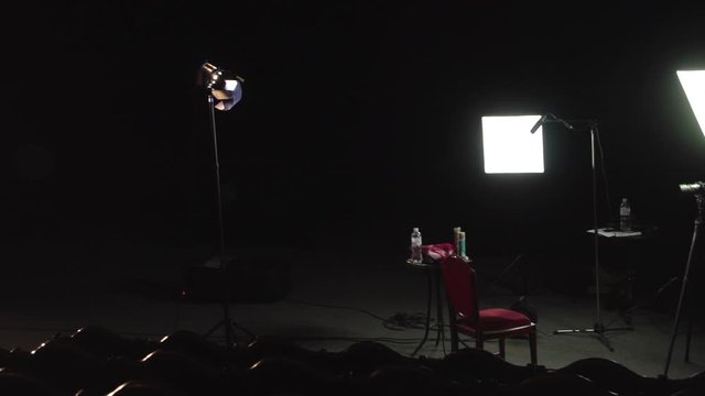 Documentary movie film set on theater stage three point lighting setup camera tripod director seat