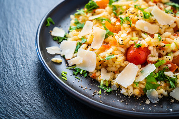 Risotto with parmesan on black stone background