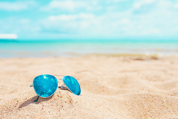 Fototapeta na wymiar Sun glasses on Sand Beach Summer Holiday Travelling background.
