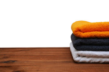 Pile of clean towels on wooden ackground and isolated on white background