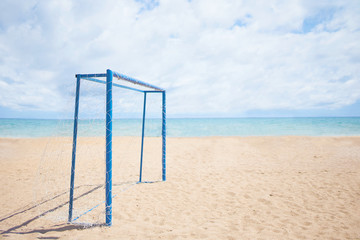 Football goal on the shore. View of the sea beach through the blue, football goal.