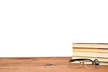 Stack of books, glasses on the rustic wooden table and isolated on a white background with copyspace