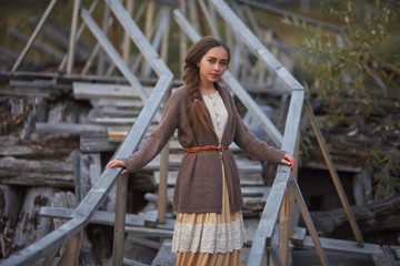 girl in vintage dress stands on a bridge