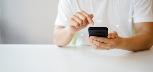 close up businessman hand holding smartphone and go to setting for turn on wifi connection to playing multimedia on cyber internet network at home , lifestyle people with comfortable technology	