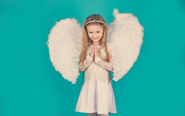 Valentines Day. Angels little hands crossed for you. Mischievous little angel girl standing with your clenched fists. Beautiful little angel girl standing with your arms close to your chest as in