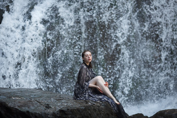 Fototapeta na wymiar Girl on a background of a waterfall.