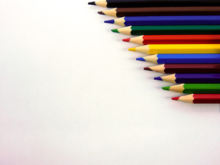  multicolored wooden pencils on a white sheet of paper