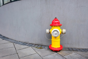 Bright hydrant in a cityscape on a gray wall