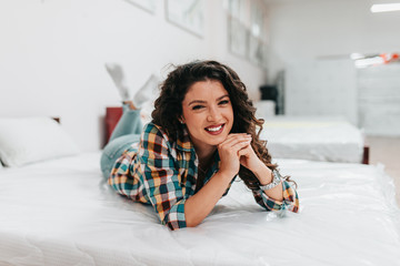 Beautiful and happy middle age woman choosing new bed and mattress in big furniture store