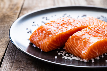 Fresh raw salmon steaks on wooden board