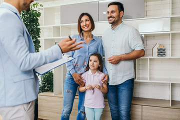 Happy family talking with real estate agent about buying a new home.