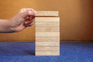Hand arranging nine wood blocks stacking on top with wooden table. Business concept for growth success process