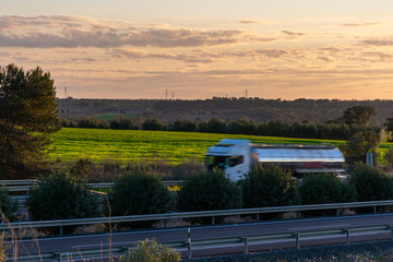 Tanker truck moving along the highway at sunset