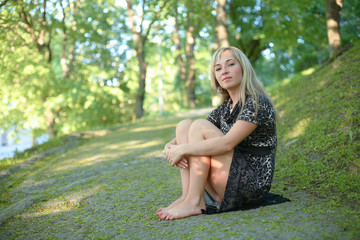 girl in dress posing while standing in park