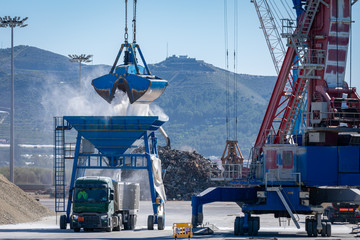 Crane in the port unloading a ship carrying fertilizer