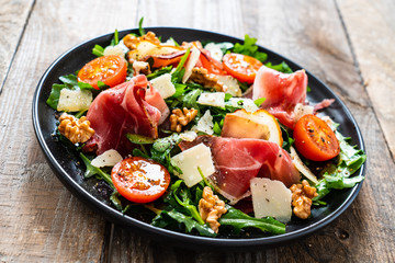 Tasty salad - ham and vegetables on wooden background