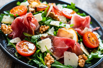 Tasty salad - ham and vegetables on wooden background