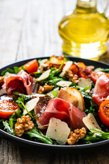 Tasty salad - ham and vegetables on wooden background