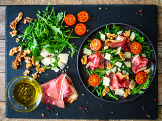 Tasty salad - ham and vegetables on black stone board