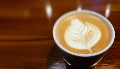 Hot art Latte Coffee in a cup on wooden table background.