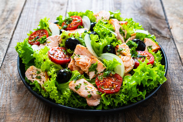 Salmon salad - roasted salmon and vegetables on wooden background