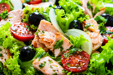 Salmon salad - roasted salmon and vegetables on wooden background