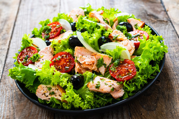 Salmon salad - roasted salmon and vegetables on wooden background