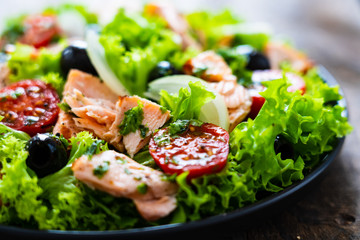 Salmon salad - roasted salmon and vegetables on wooden background