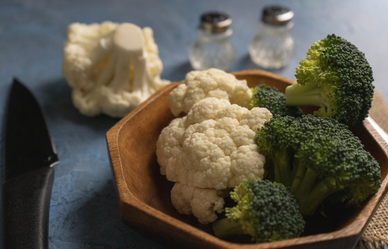 Br&eacute;col fresco y coliflor fresco cruda en un cuenco de madera