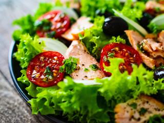 Salmon salad - roasted salmon and vegetables on wooden background