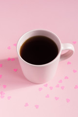 Pink cup of teea on pink background ith hearts. Love and care concept. Minimal style