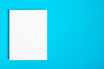 Mockup of closed blank square book at white textured paper background