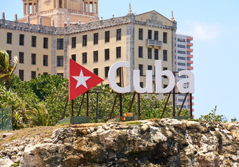 Cuba word sign with red triangle and a star over Hotel Nacional in Havana Cuba